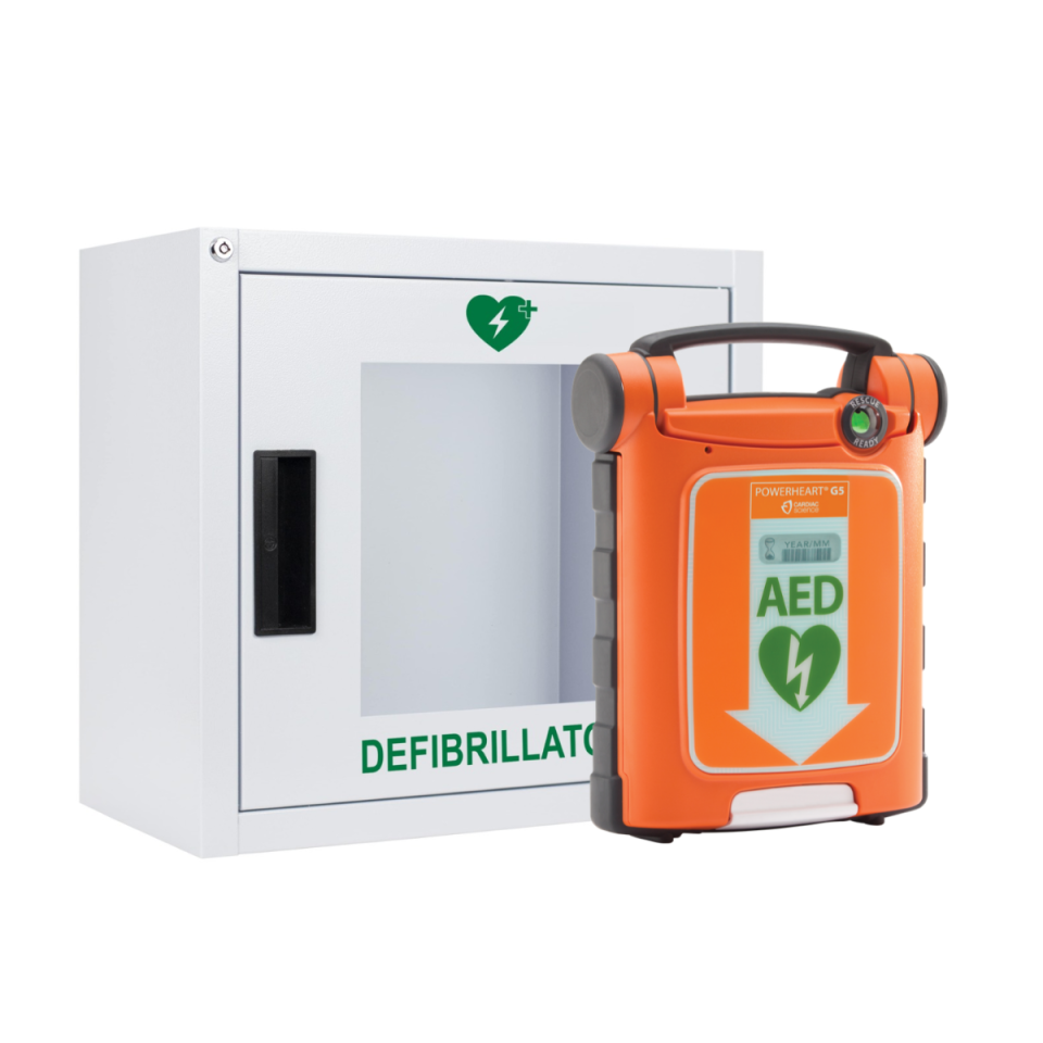Indoor white metal, alarmed defibrillator cabinet with large viewing window, next to cardiac Science G5 Defibrillator next to Defib Store with Rescue Ready Kit 
