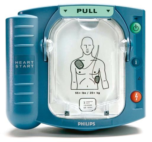 Front face of semi-automatic Philips Heartstart HS1 defibrillator showing pad placement on adult patient with push to shock button