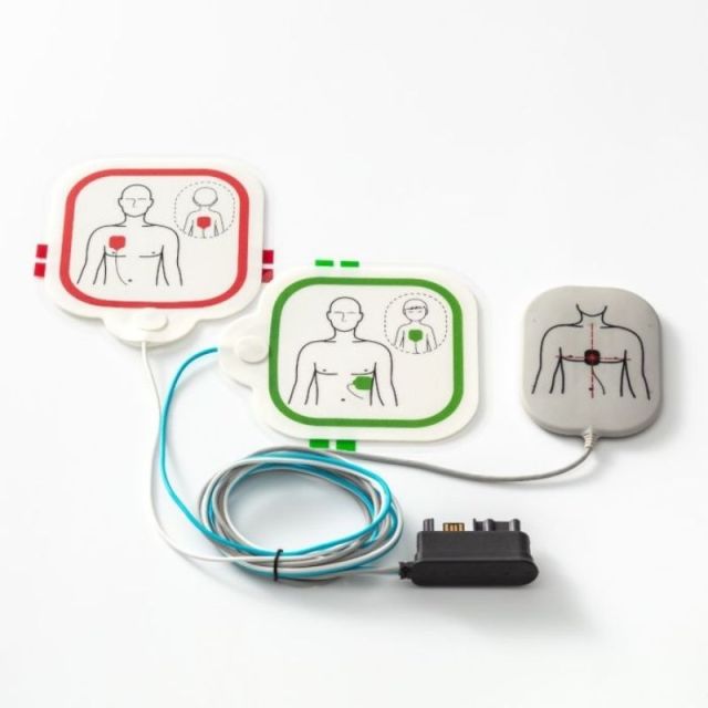 Primedic HeartSave Y and YA CPR feedback electrode pads showing adult red border pad, paediatric green border pad, and CPR compression feedback sensor puck