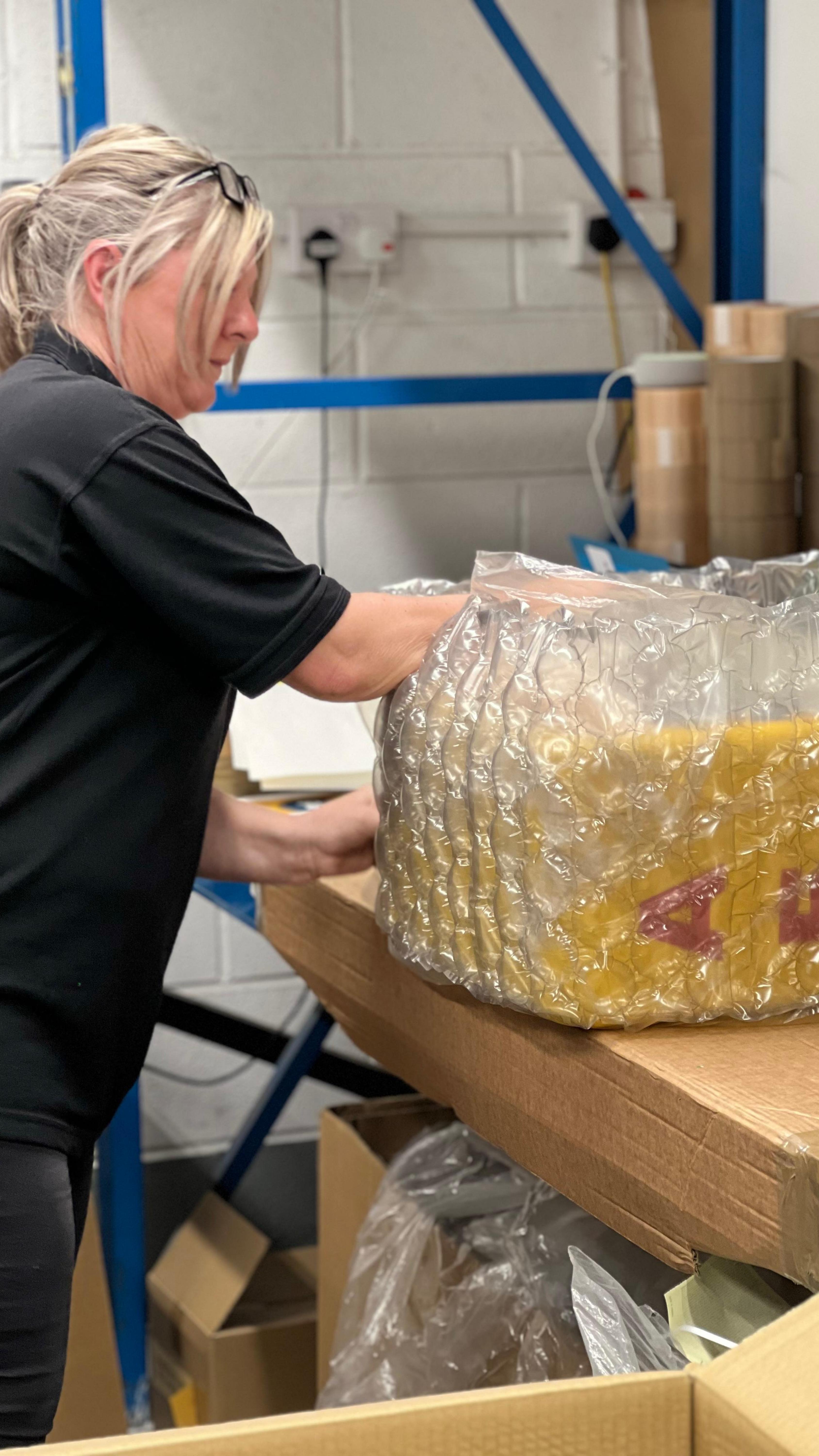 Hand-built defibrillator cabinet - made in Derbyshire Defibstore engineer hand-assembling yellow AED cabinet with internal heater and mounting bracket at UK workshop